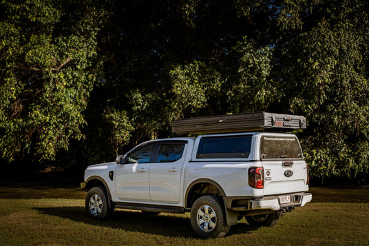 White Ford Ranger Next Gen with a white CapRax canopy and a rooftop tent on the roof